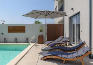 eine Gruppe von Stühlen mit einem Sonnenschirm neben einem Pool in der Unterkunft Villa Diva Istria in Nova Vas