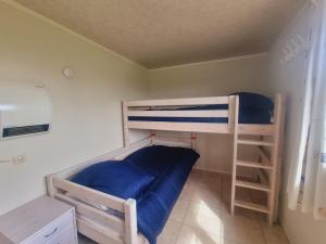 ブランケンベルヘにあるBeachside Vakantieparkのベッドルーム1室(二段ベッド2組、青いシーツ付)