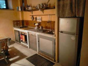 una pequeña cocina con fregadero y nevera. en AL LOFT, Centro Storico en Prato