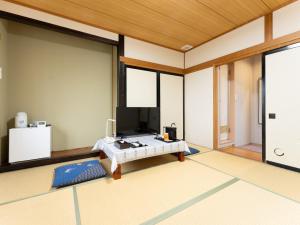 a room with a bed and a tv in it at Nasu Kogen North Inn in Higashikoya
