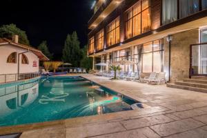 a swimming pool in front of a building at night at Katalina SPA Resort in Tsigov Chark