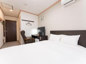 a bedroom with a large bed and a desk at Nasu Kogen North Inn in Higashikoya