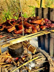 Un tas de nourriture est en train de cuisiner sur un grill. dans l'établissement Palm Hill Chalet, à Ha Giang