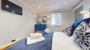 Schlafzimmer mit einem Bett und einem TV an der Wand in der Unterkunft Swansea Marina - 3 Bed Apartment - Water Views & Free Parking in Swansea