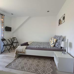 Dormitorio blanco con cama y mesa en Noclegi U Janusza 536-310-384 en Polańczyk