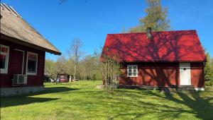 una casa roja con techo rojo en un patio en Your getaway home in Jausa küla, en Hiiumaa