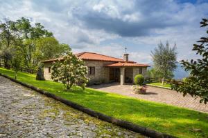 una casa con una entrada de piedra y un patio de césped en Casa de Padreiro, en Caniçada