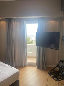 um quarto com uma cama e uma grande janela em Kreoli Hotel em Atenas