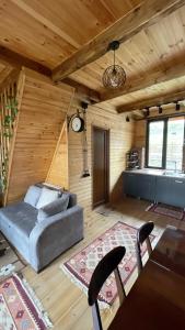 sala de estar con sofá y mesa en AURA Cottages, en Kazbegi