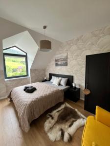 a bedroom with a bed with a furry rug at JÁNOŠÍK Apartmány in Terchová