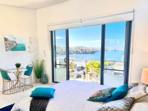 雪梨的住宿－Picture-Perfect Masterpiece In Exclusive Mosman，一间卧室配有一张床,享有海景