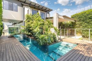 a house with a swimming pool in front of a house at Picture-Perfect Masterpiece In Exclusive Mosman in Sydney