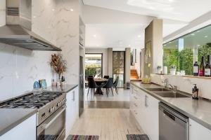 雪梨的住宿－Picture-Perfect Masterpiece In Exclusive Mosman，一个带白色台面的大厨房和一个饭厅