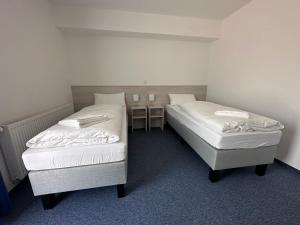two twin beds in a room with a table at Marina Park Eberswalde in Eberswalde