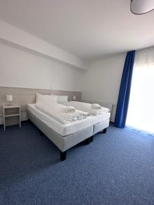 sypialnia z dużym białym łóżkiem i oknem w obiekcie Marina Park Eberswalde w mieście Eberswalde