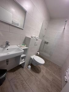 biała łazienka z toaletą i umywalką w obiekcie Marina Park Eberswalde w mieście Eberswalde