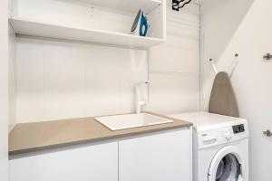 雪梨的住宿－Picture-Perfect Masterpiece In Exclusive Mosman，厨房配有水槽和洗衣机