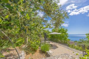 a patio with an umbrella and the ocean in the background at Holiday home Tranquillo in Makarska