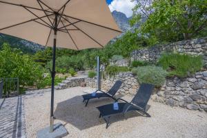 two chairs and an umbrella on a patio at Holiday home Tranquillo in Makarska +42 photos