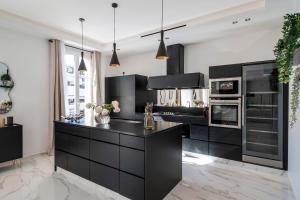 czarna kuchnia z czarnymi szafkami i urządzeniami w obiekcie REF 1466 - Cannes Back Croisette - Penthouse for rent w Cannes