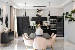 kuchnia z czarnymi szafkami, stołem i krzesłami w obiekcie REF 1466 - Cannes Back Croisette - Penthouse for rent w Cannes