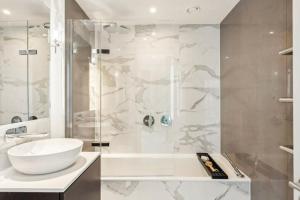 een witte badkamer met een wastafel en een douche bij Hestia Residences in Londen