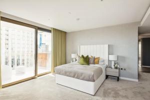 een slaapkamer met een groot bed en een groot raam bij Hestia Residences in Londen