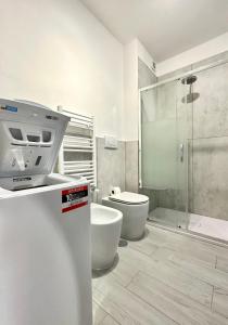 uma casa de banho com um WC e uma cabina de duche em vidro. em Fratelli Bandiera em Latina