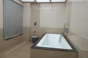 a bathroom with a bath tub and a toilet at Hotel Apratim Lodging & Boarding in Ambernath