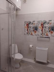 Un baño con inodoro y un cuadro en la pared. en House, garden & sauna. Free parking. Train stop-200 m. Sea-1 km., en Jūrmala