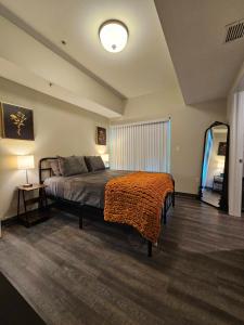 - une chambre avec un lit recouvert d'une couverture orange dans l'établissement Brand New HUGE Apartment Next To Mayo, Park Free, à Rochester