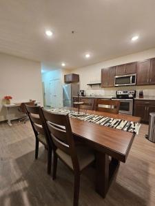 uma grande cozinha com uma mesa de madeira e cadeiras em Brand New HUGE Apartment Next To Mayo, Park Free em Rochester