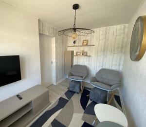 a living room with two chairs and a tv at Bi AIN venue in Pont-de-Poitte