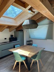una mesa de madera y sillas en una cocina con techo en Chalet 181 Grand Haury en Arvier