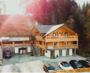 博尔沙Cabana Repedea的一座大型木屋,前面设有停车场