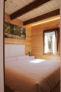 een bed in een houten kamer met een raam bij O Rincón das Rías Baixas in Bueu