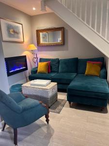uma sala de estar com um sofá azul e cadeiras em Boutique Townhouse in Christchurch Dorset em Christchurch