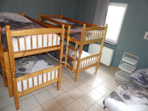 une chambre avec trois lits superposés et une fenêtre dans l'établissement Coeur de Loup, à Sourbrodt