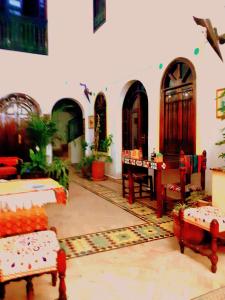 una sala de estar con sillas y mesa y una habitación con en Riad Sesame, en Marrakech