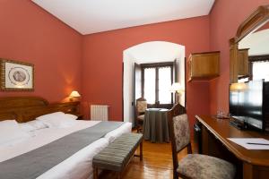 ein Hotelzimmer mit einem Bett und einem Schreibtisch mit einem Computer in der Unterkunft Hostería del Monasterio de San Millan in San Millán de la Cogolla