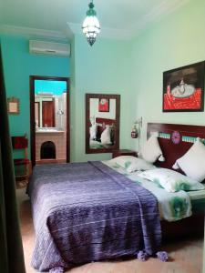 1 dormitorio con 1 cama con manta morada en Riad Sesame, en Marrakech