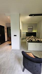 een slaapkamer met een bed, een bank en een stoel bij Confidentiel Standing - Terrasse & Parking Privé - Port de Plaisance in Évian-les-Bains