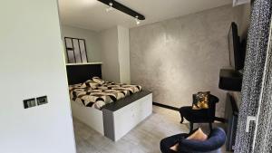 ein Schlafzimmer mit einem Bett und zwei Stühlen darin in der Unterkunft Confidentiel Standing - Terrasse & Parking Privé - Port de Plaisance in Évian-les-Bains