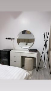 شقة فندقية تصميم مودرن في الرياض: غرفة نوم مع مرآة ومكتب أبيض