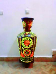 Un vaso colorato seduto accanto a un muro di Riad Sesame a Marrakech