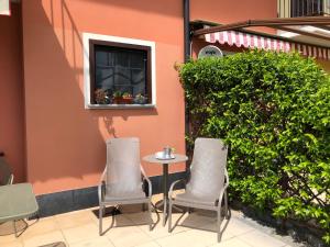 een tafel en stoelen voor een gebouw bij Irina’s house with view on like and swimming pool in Riva di Solto
