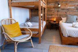 a room with two bunk beds and a chair at Alex Surf Hostel in Baleal