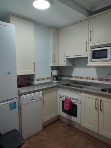 cocina con armarios blancos y fogones en Apartamento Florida-Natura Oviedo, en Oviedo