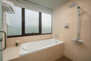 eine Badewanne im Bad mit Fenster in der Unterkunft HB Serviced Apartment - 121B Quan Hoa in Hanoi