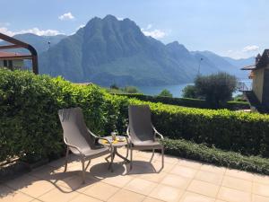 twee stoelen en een tafel met uitzicht op een berg bij Irina’s house with view on like and swimming pool in Riva di Solto